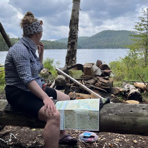 Baby Legs sitting on a log at the former South Lake Lean-to site assessing the map and looking at the approaching weather.