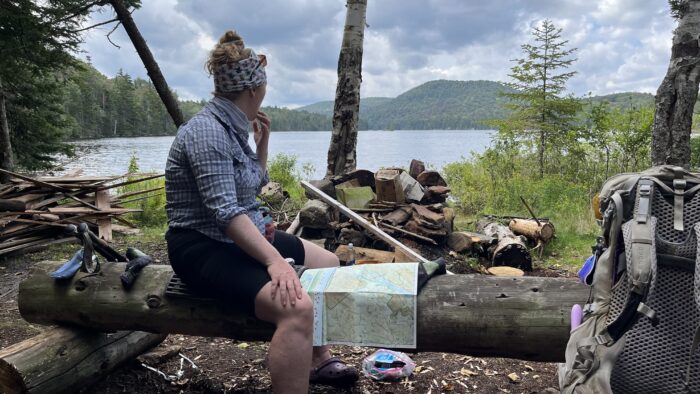 Baby Legs sitting on a log at the former South Lake Lean-to site assessing the map and looking at the approaching weather.