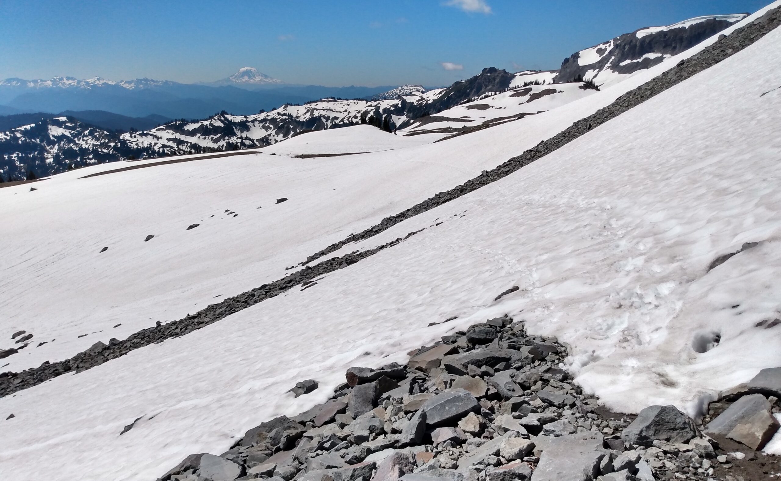 a snowy slope with mountains in the background