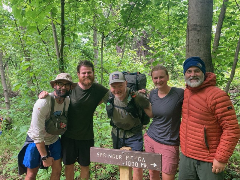 A photo of Pumba, me, Grasshopper, Dingo and Rex in front of a sign that says "SPRINGER MT 1000 Mi."