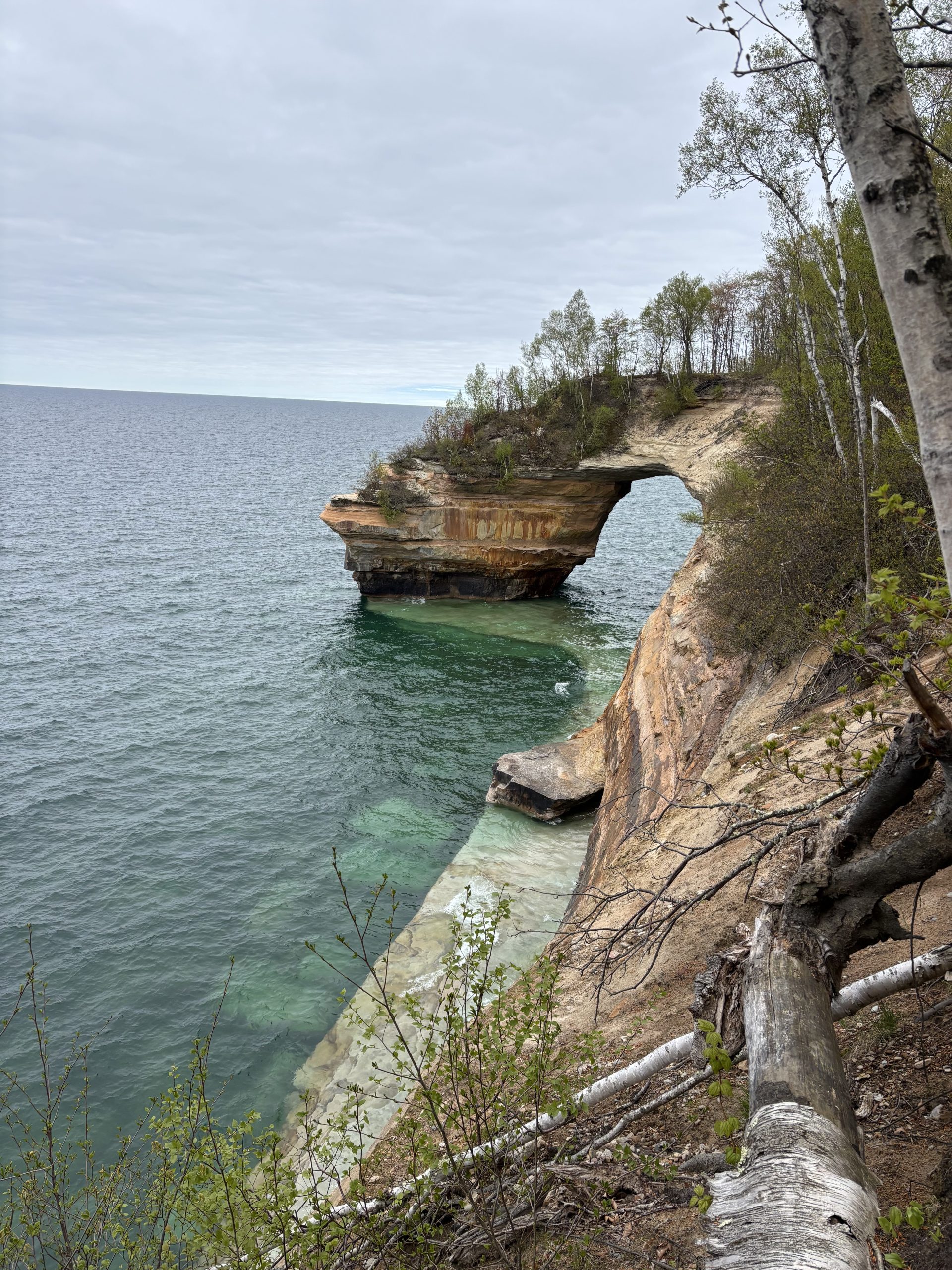 A massive, naturally formed arch of stone sticks out into Lake Superior