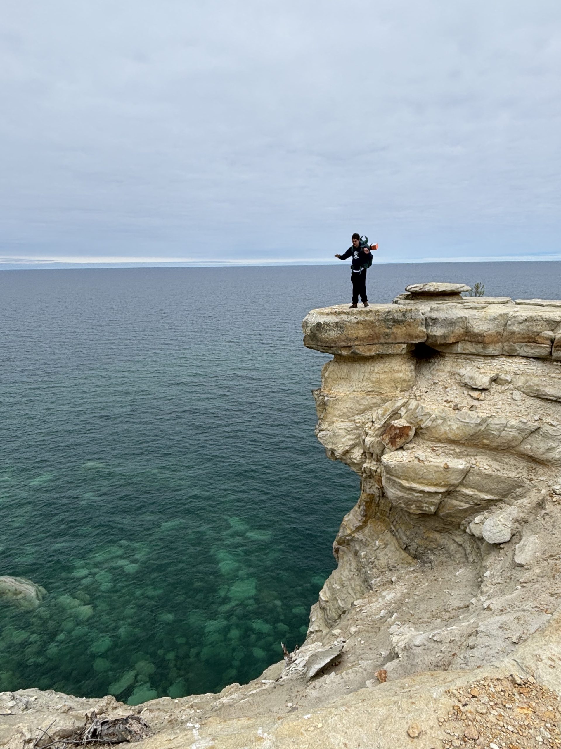 The writer, standing on a rocky overhang with his arms out for balance.
