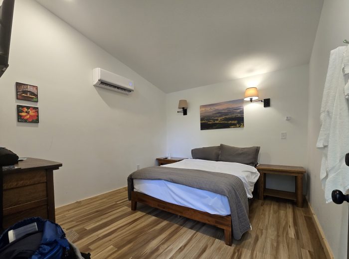small lodge room with bed and dresser but no chairs