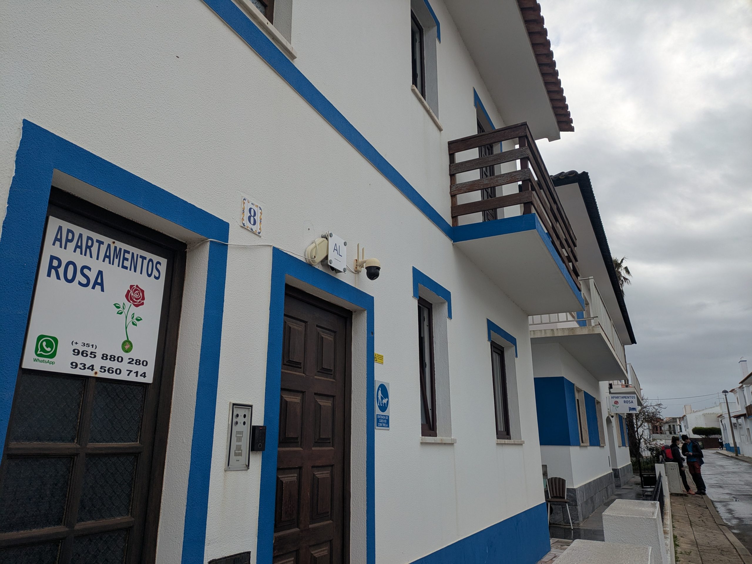 A cozy and whitewashed apartments building in Porto Coval, Portugal, a simple and charming accommodation under a clear sky