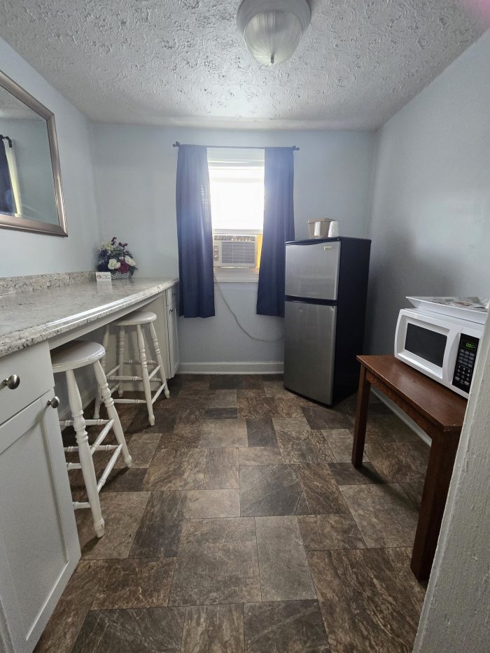 Kitchen with counter, VAR stools, small and microwave refrigerator