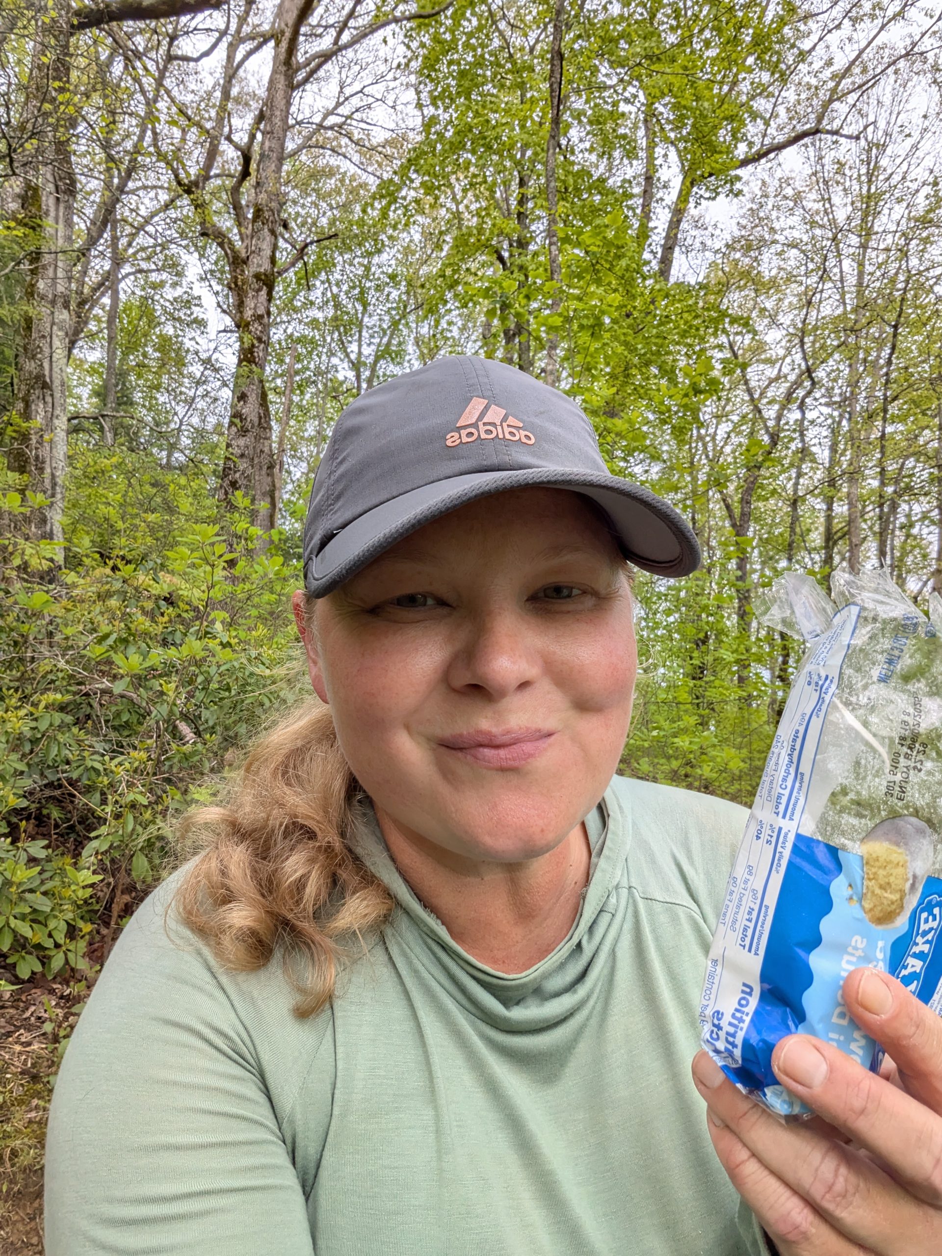 Hiker holding up donut pack.