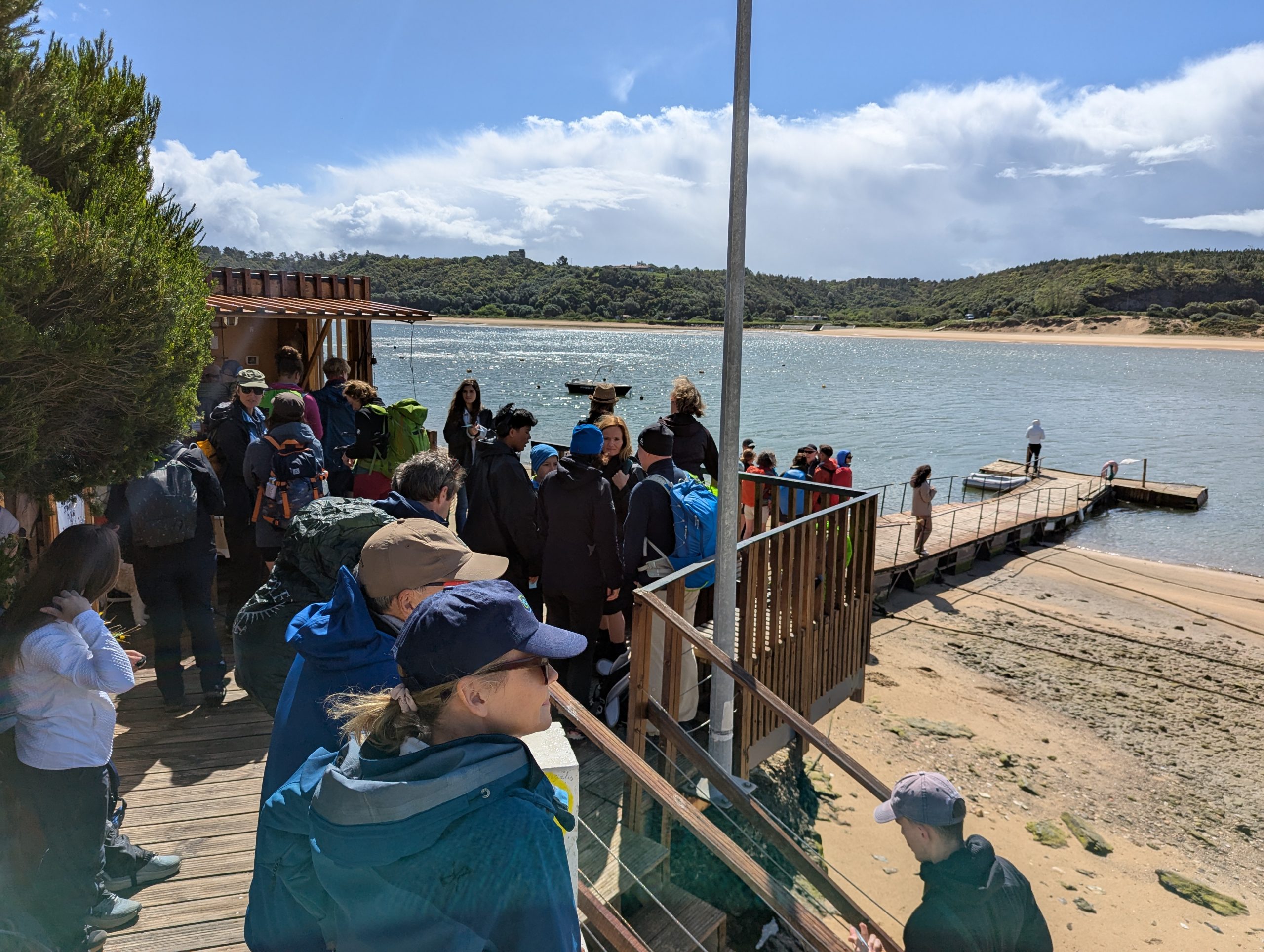Un grupo de excursionistas espera en la playa cerca de Vila Nova de Milfones para el ferry Ferry Miri en el carril de los pescadores en Portugal.