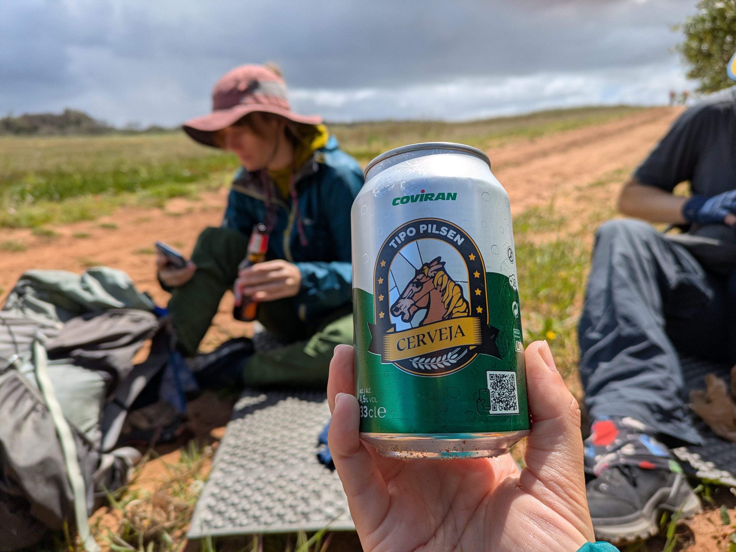 El excursionista se sienta en el suelo, el almuerzo con cerveza puede estar en un lugar seguro en el sendero cuando los pescadores en Portugal.