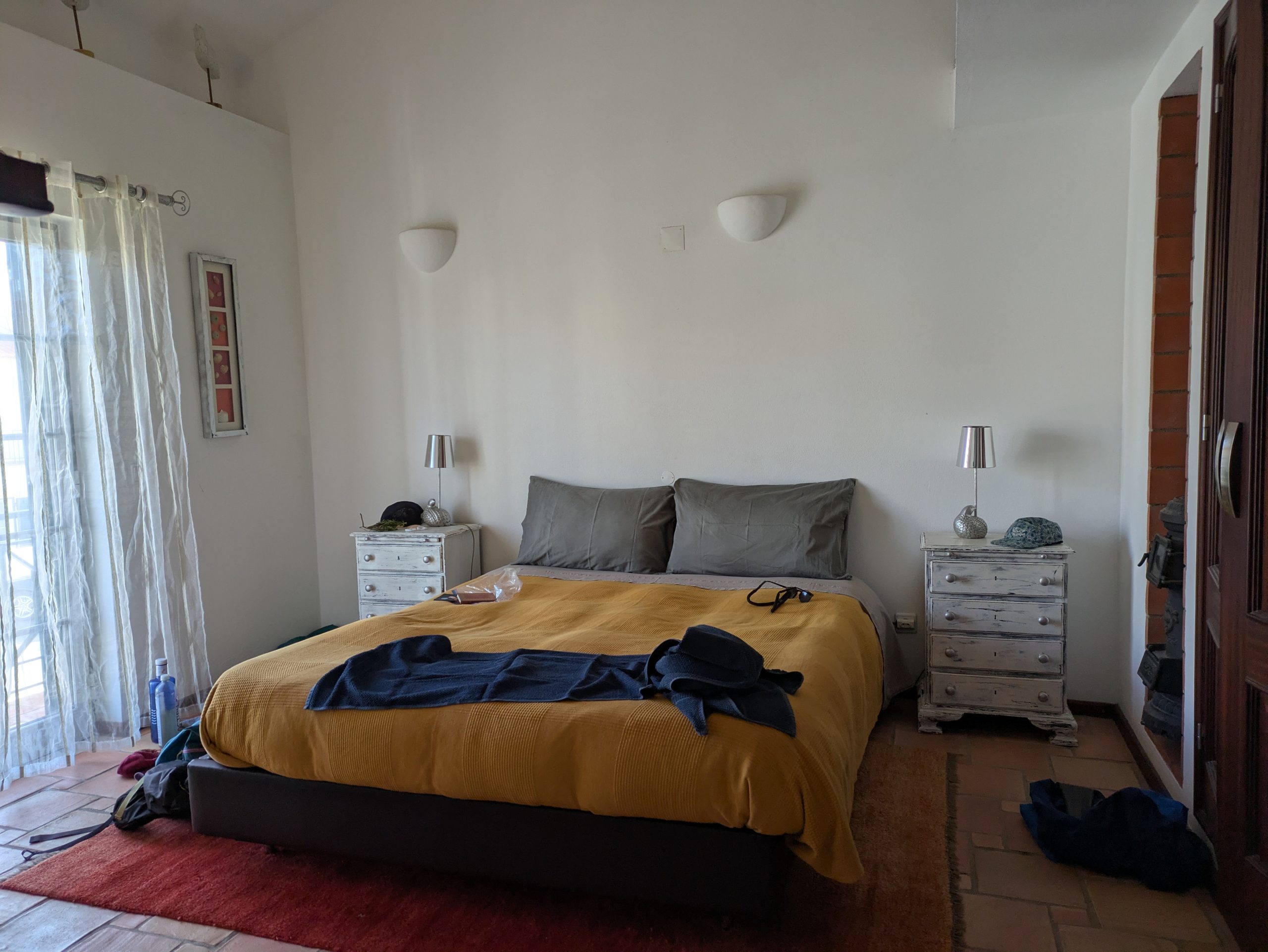 Una cama hecha dentro del apartamento que tiene un poco de alcohol.