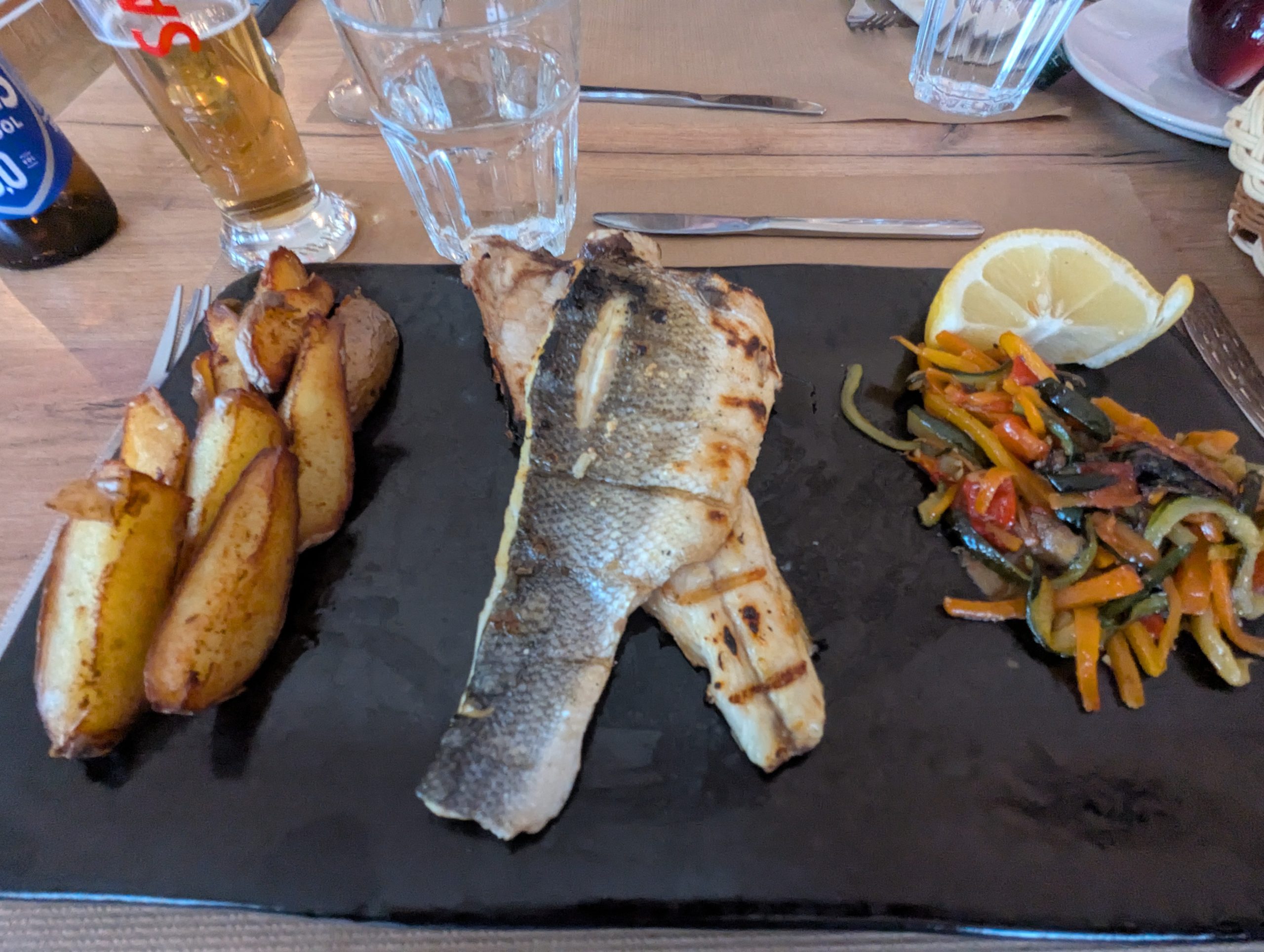 Grilled fish dish with roasted potatoes and vegetables in a restaurant in sagres after walking along the path of fishermen.