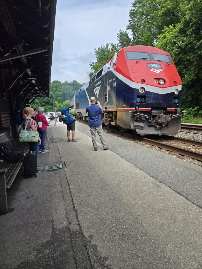 Máquina amactante roja con autos de tren en estaciones 