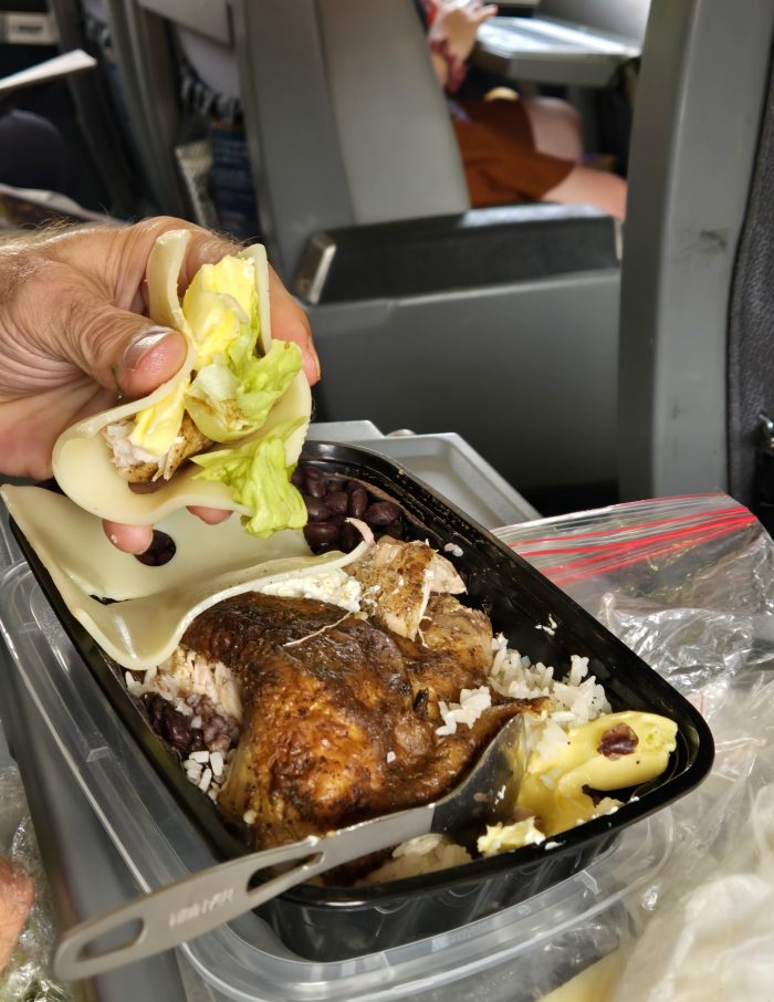 Atrapa a mano comida envuelta en una rebanada de códigos suizos que flotan en bandeja de arroz, nueces y pollo