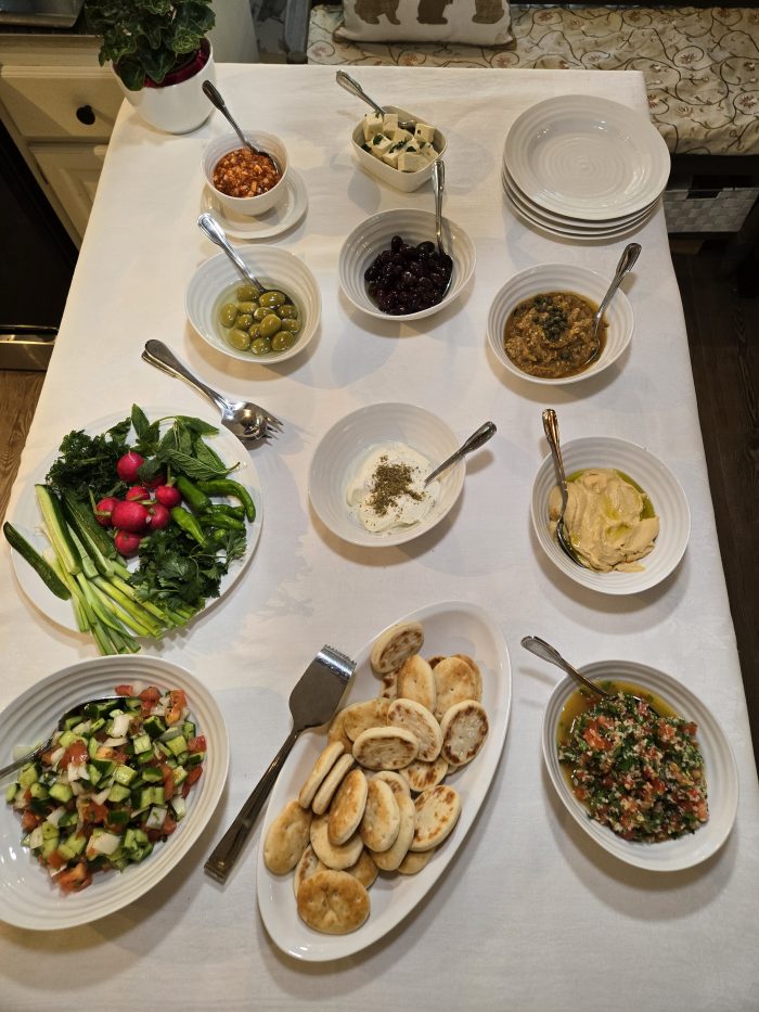 homemade mezza buffet including flatbread and multiple salads and herbs