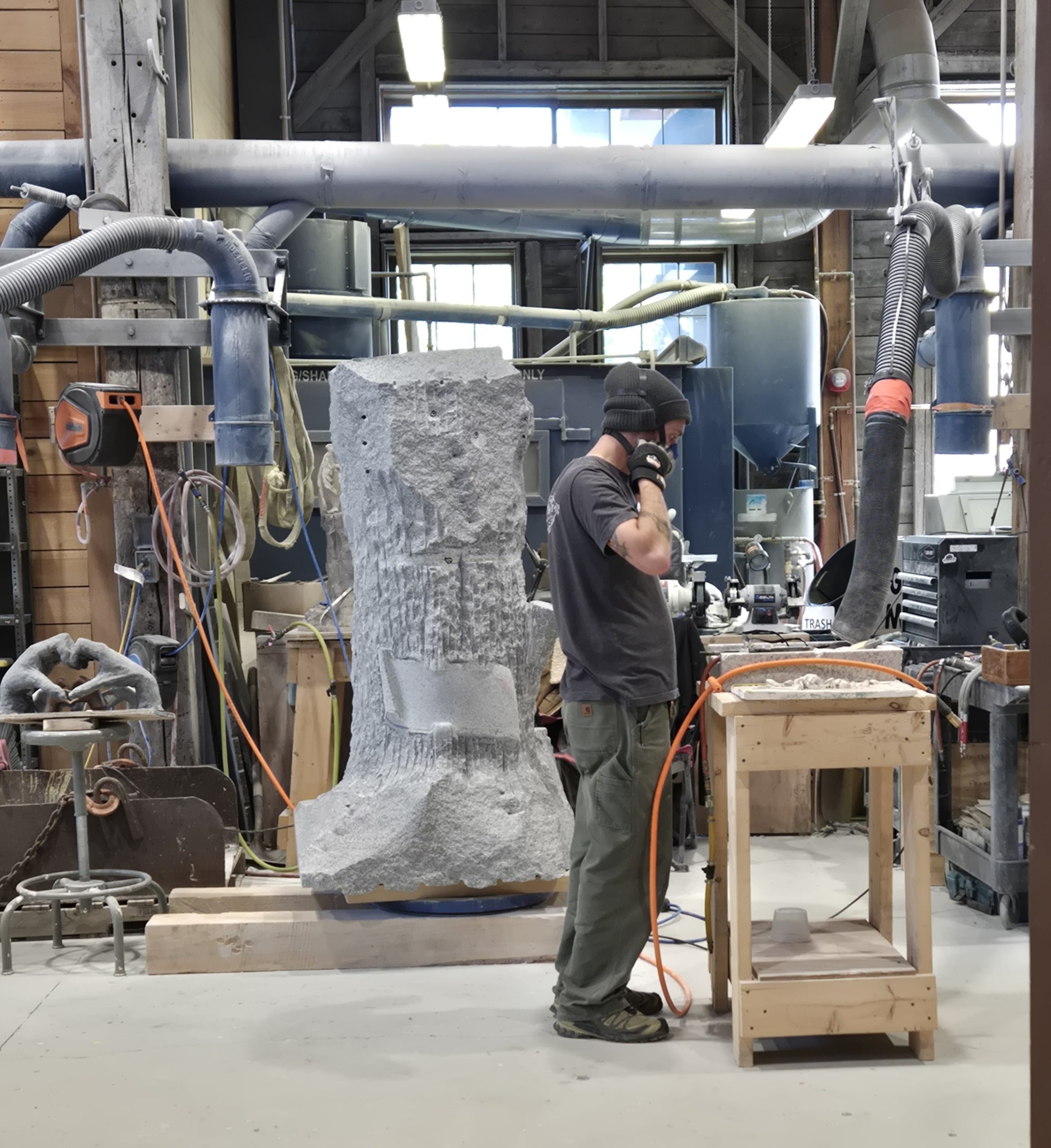 Man carving granite in a granite shed