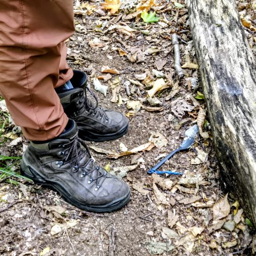 Close up of two hikong boots and a spork on tje ground