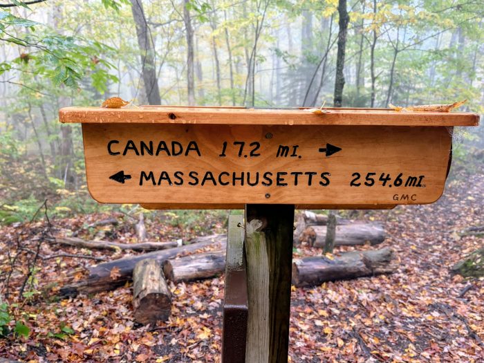 Wooden sign saying Canada, 17 and one half miles