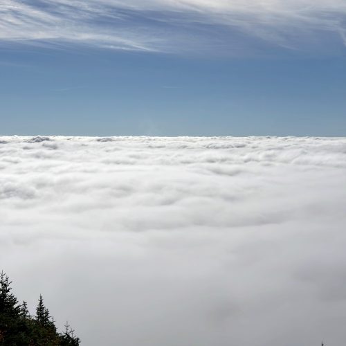 View of clouds below a Moutain peak
