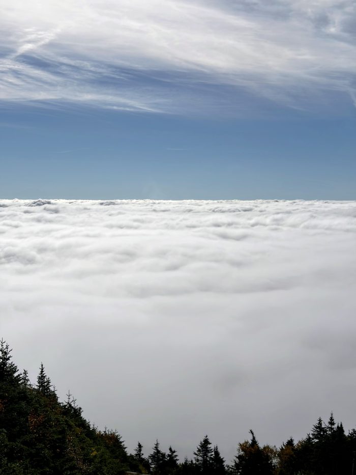 View of clouds below a Moutain peak